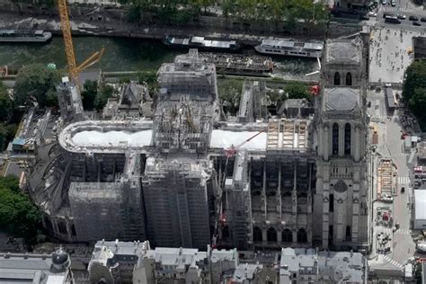 Oak trusses raised to roof of fire-ravaged Notre Dame Cathedral as crowds watch along the Seine